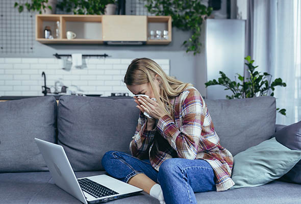 Γυναίκα που κλαίει μπροστά στον υπολογιστή της.
